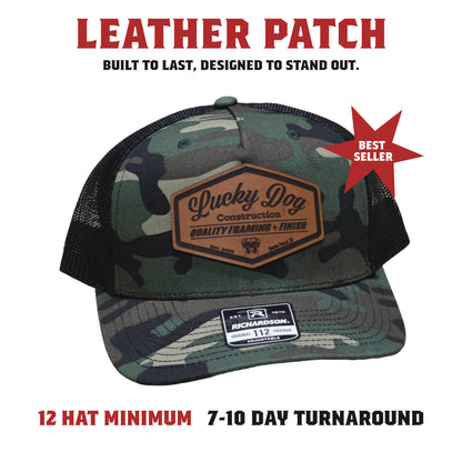 A structured hat featuring a stitched-on genuine leather patch with engraved detailing. Offers a rugged, premium look built for long-lasting wear